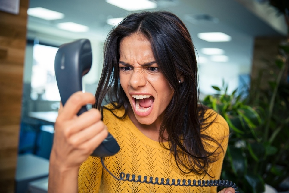 Image of an angry woman calling a business