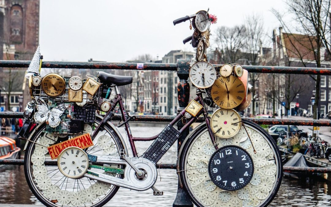 A bike with many clocks on it representing 24 hours in a day